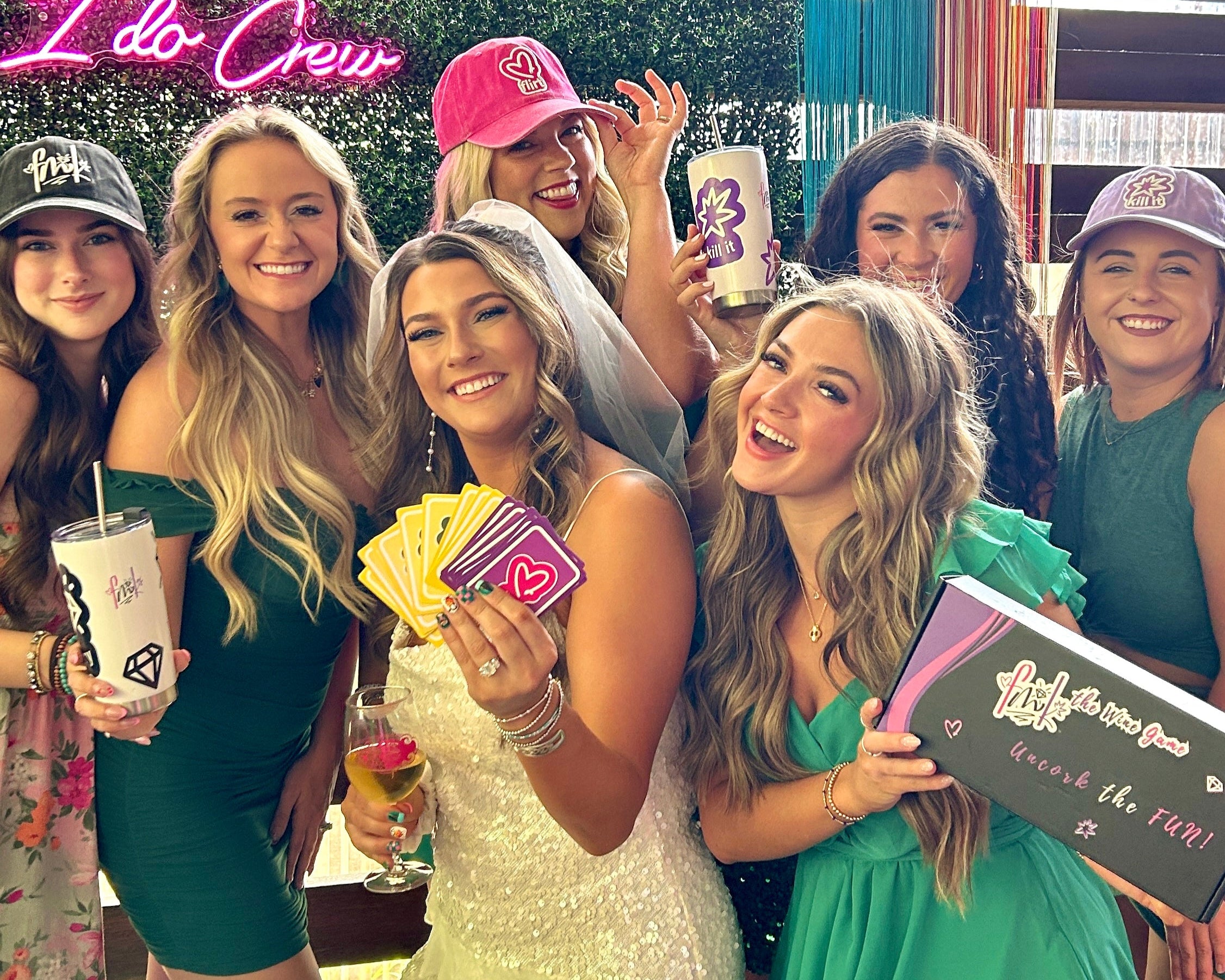 Group of women posing together with FMK party favors at a bachelorette party.
